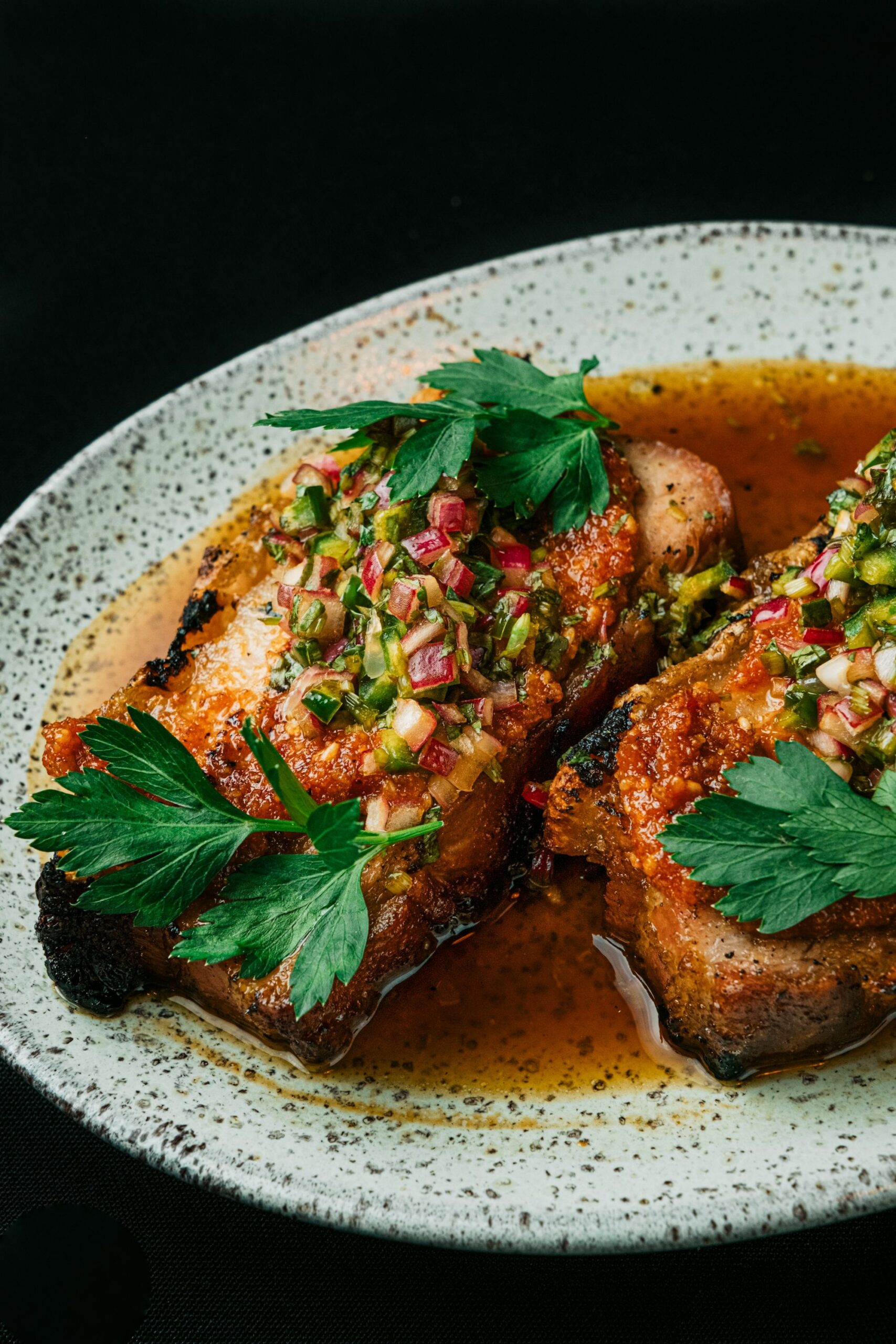 Juicy golden air fryer pork chops topped with zesty herb relish and pan juices
