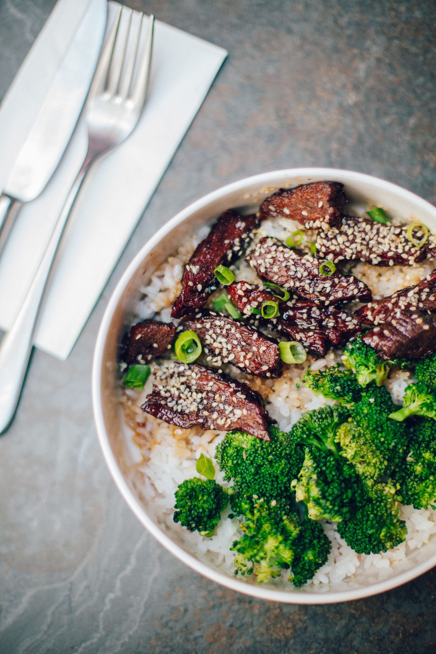 Savory tender beef and broccoli stir fry served over white rice with toasted sesame seeds