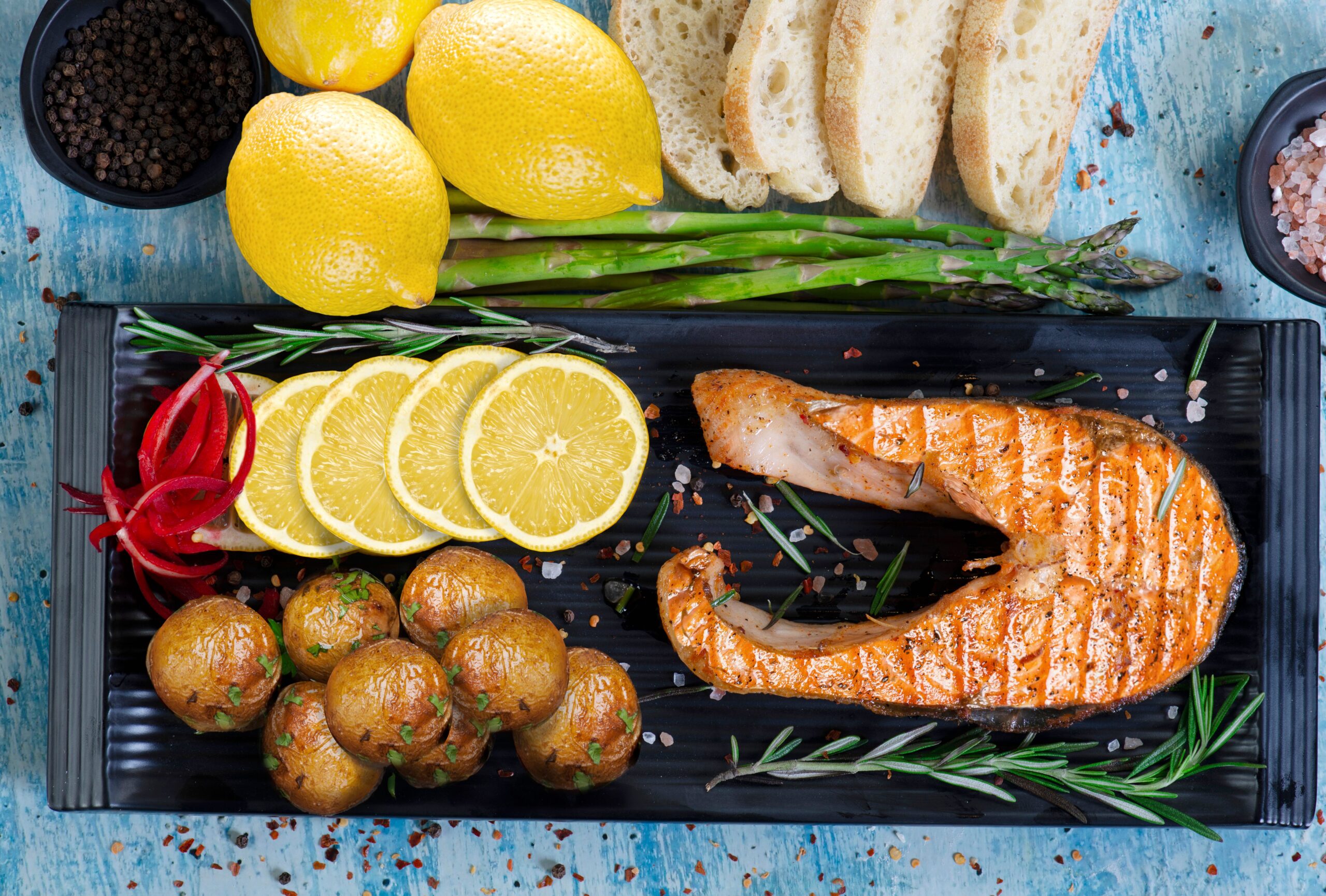 Pan-seared lemon herb salmon steak served with roasted baby potatoes and fresh herbs
