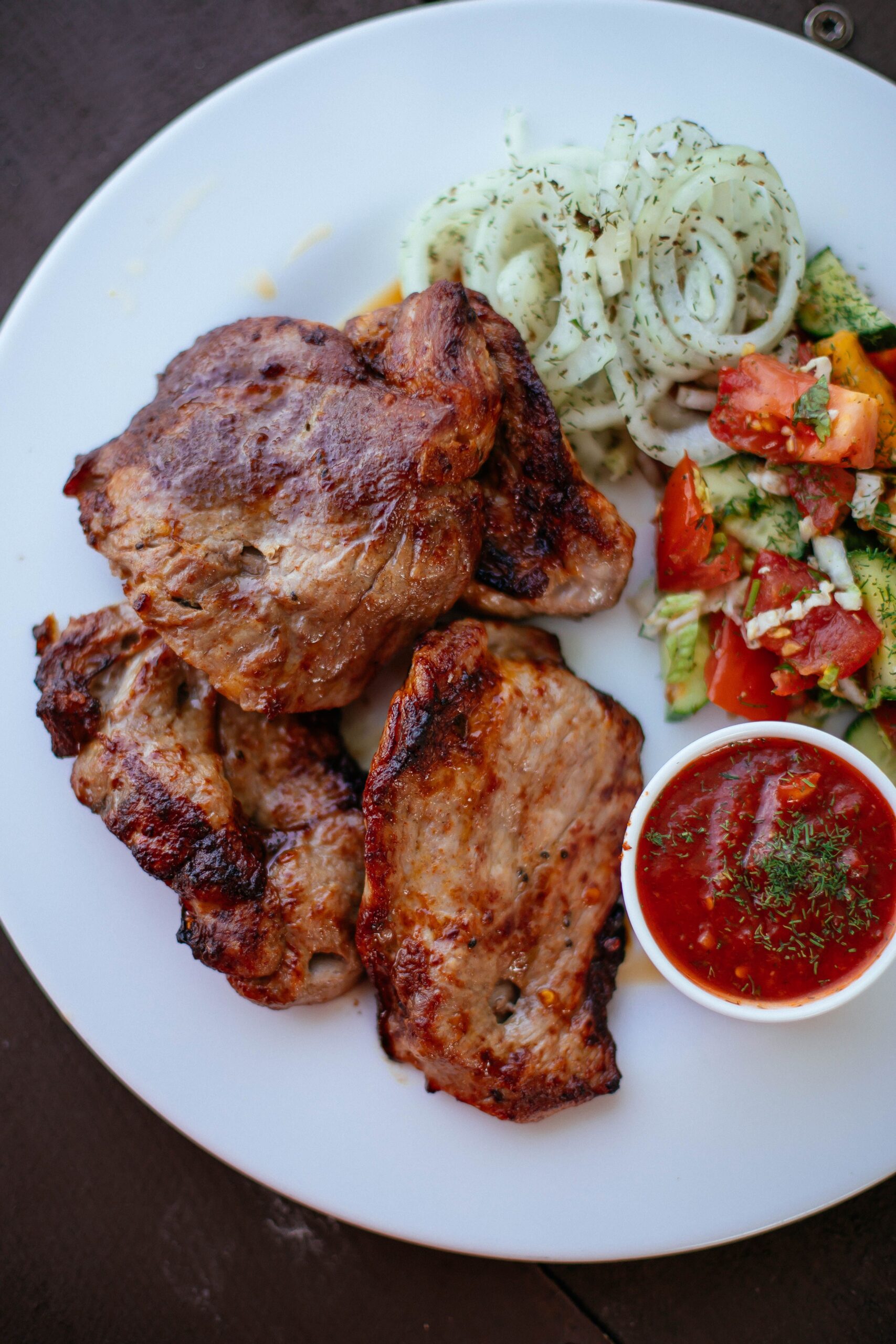 Juicy golden air fryer pork chops topped with zesty herb relish and pan juices