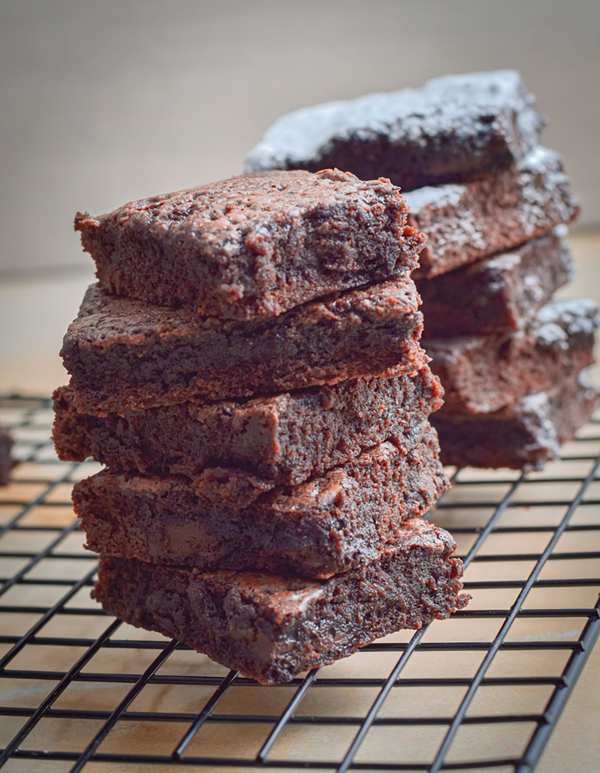 Stack of ultra fudgy dark chocolate brownies cut into squares with crinkly tops