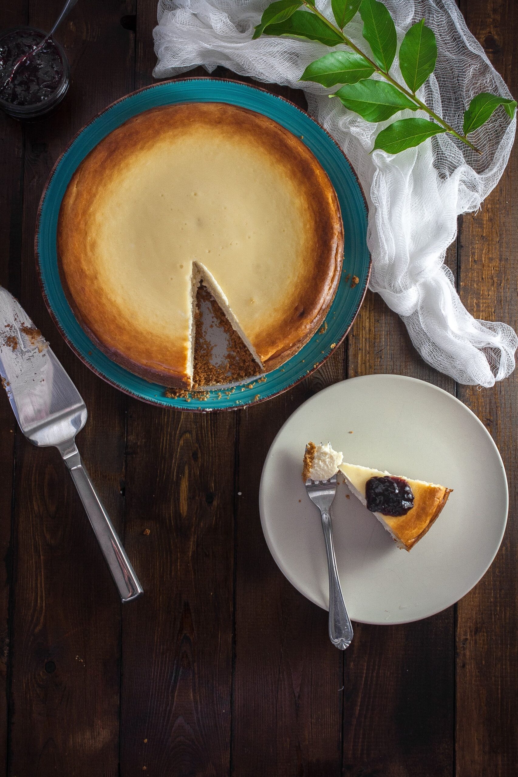 Classic slice of dense and creamy New York cheesecake served on a white dessert plate