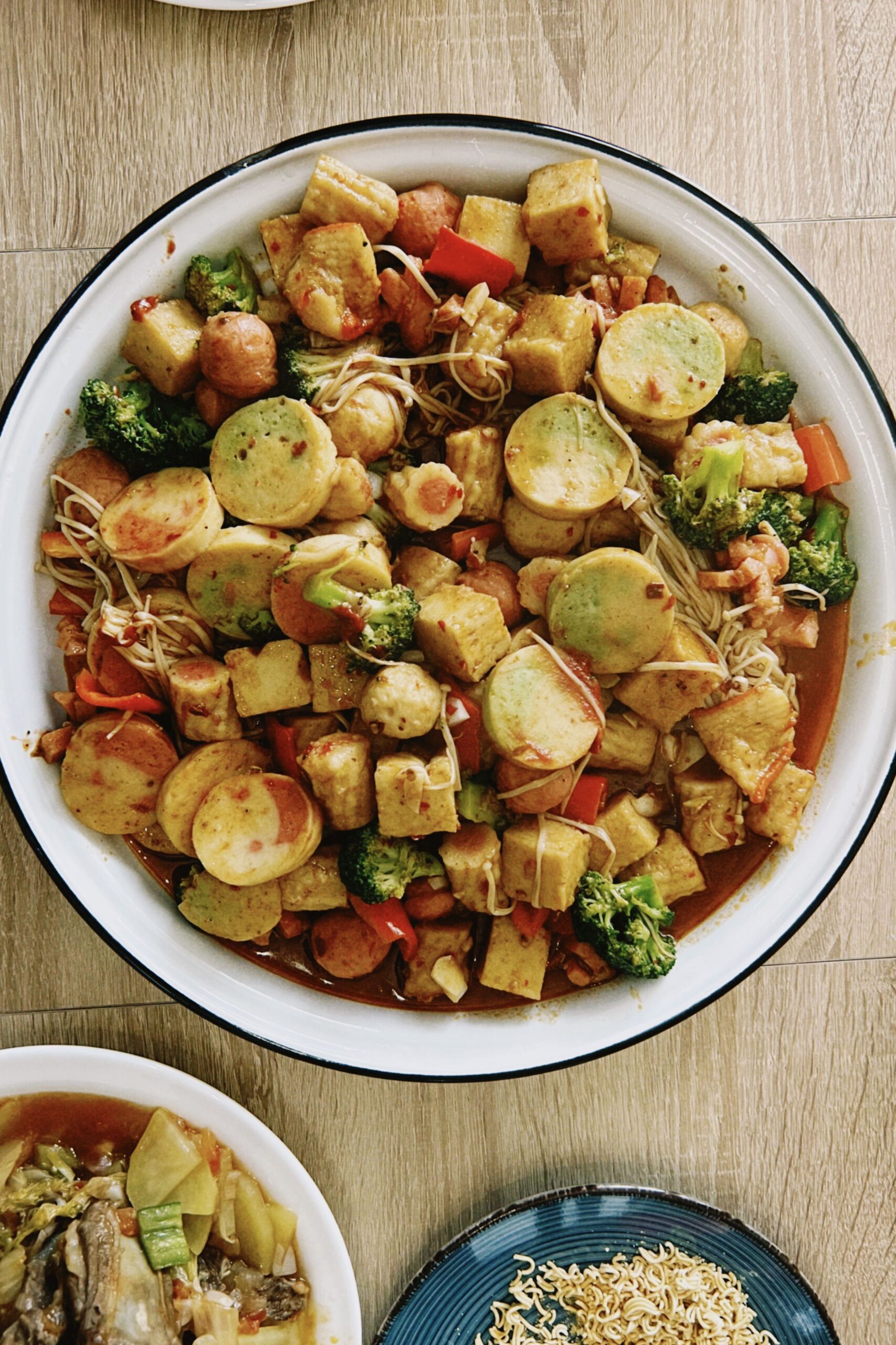 Large platter of golden pan-seared tofu medallions tossed with broccoli and vegetables