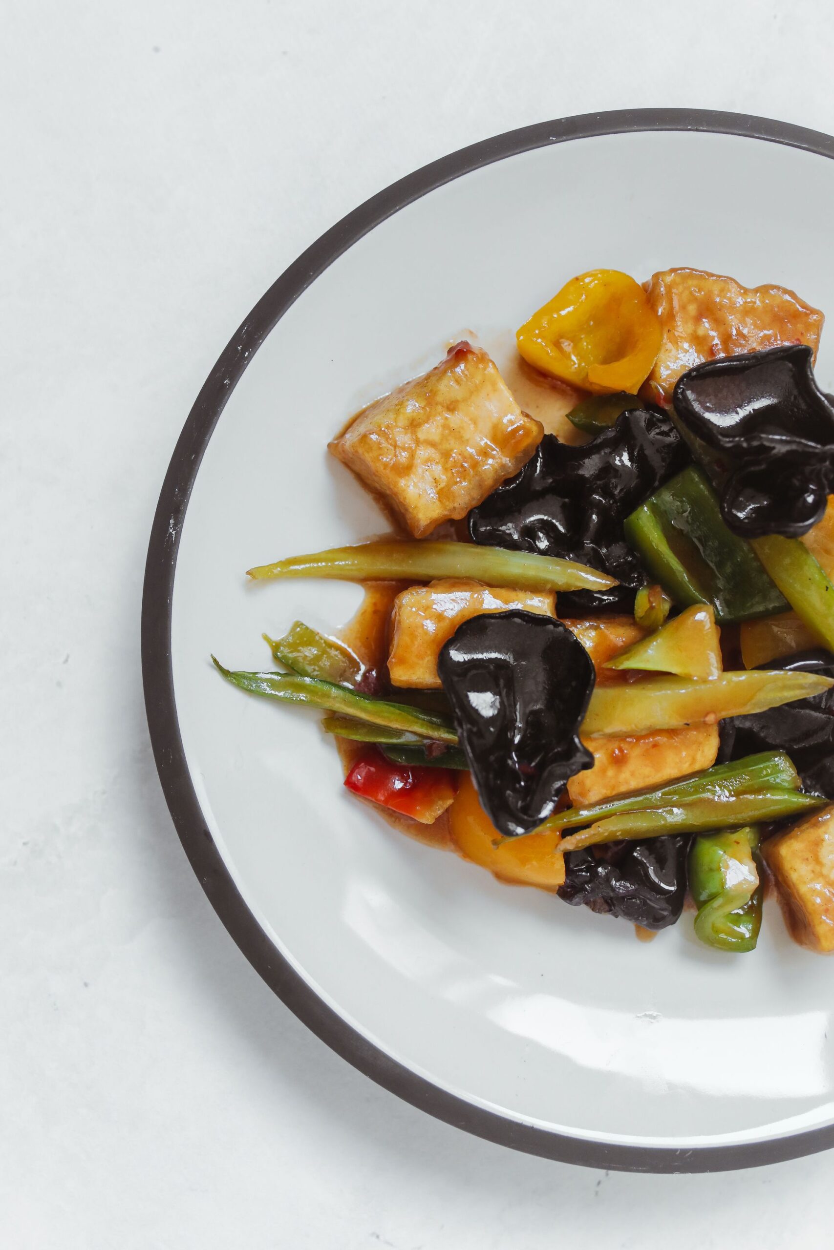 Large platter of golden pan-seared tofu medallions tossed with broccoli and vegetables
